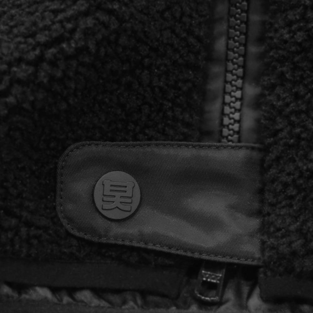 Close-up of a textured fabric surface with a brand logo on a black background